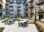 Thumbnail 5 of 53 - an outdoor patio with tables and chairs at the bradley braddock road station apartments
